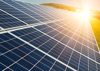 Sun rises over a row of solar panels