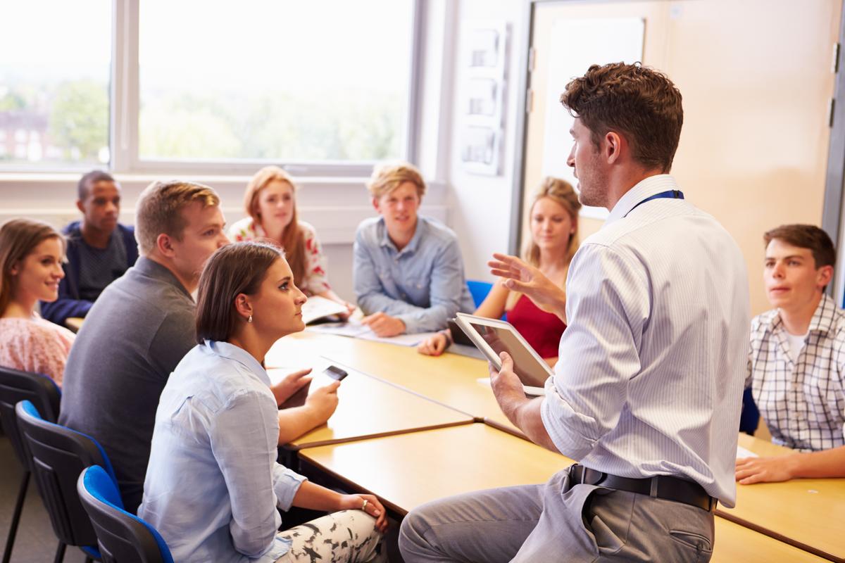 a-class-of-millennials-sits-at-a-table-listening-to-someone-speak.jpg