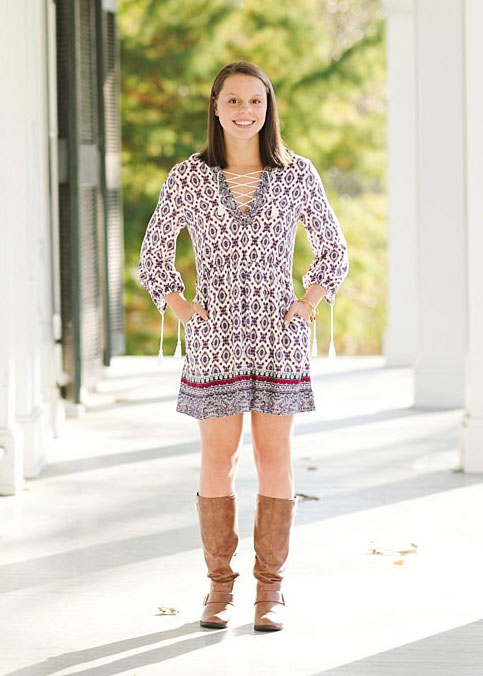 Laura Hodge standing on the front porch of a white building. Facing the camera. 