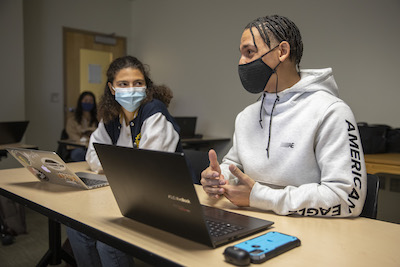 two students with laptop on desk