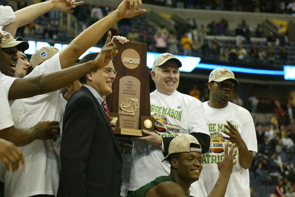 men at basketball game holding trophy