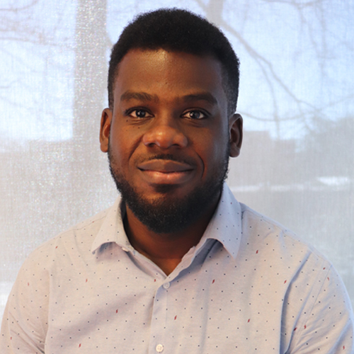 Mason assistant professor Matthew Amissah is a black man who wears a light shirt and has a beard in his profile