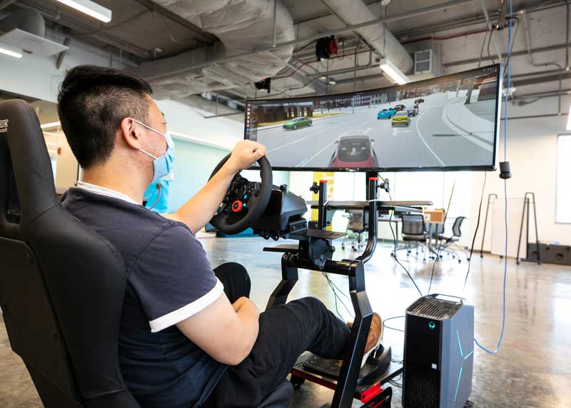Man operates driving simulator in the CYMANII pilot space at George Mason University, IDIA.