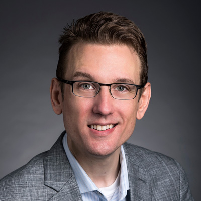 Michael Eagle wears a gray suit, light-blue shirt and glasses