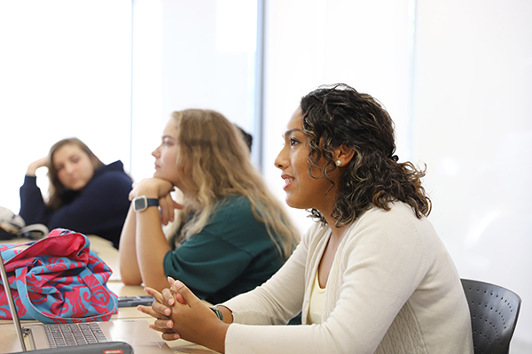 Three students in a classroom facing left