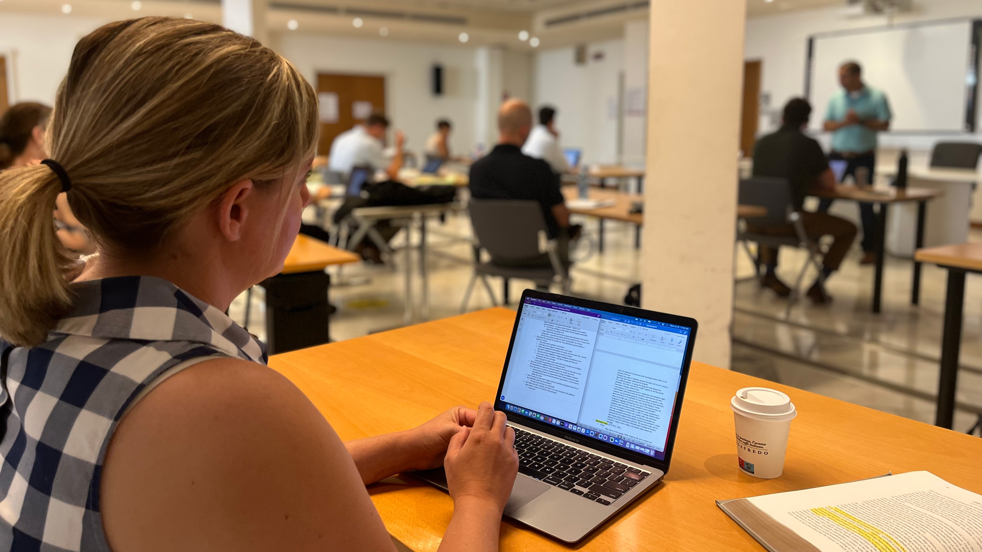 Law student Kaitlin Groundwater listening to Professor Jaffer's class. She is taking notes on a laptop.
