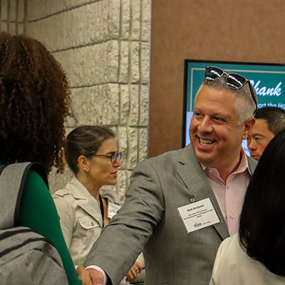 Matt McQueen, Chief Communications and Engagement Officer at Peraton, shakes hands at the awards ceremony.