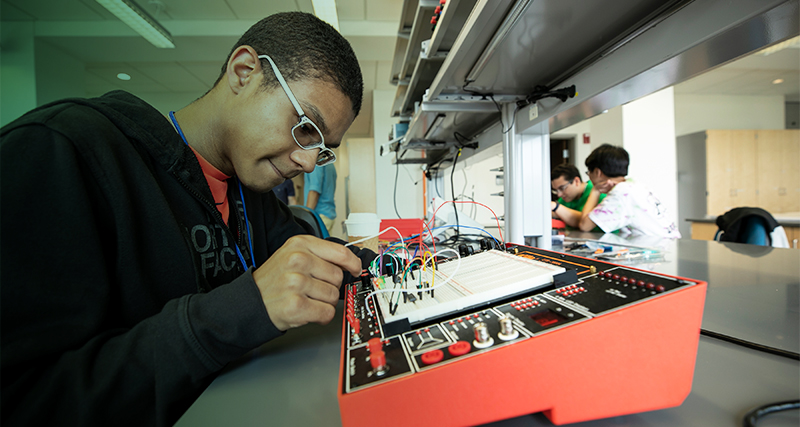 A student works with a piece of technology during a science class