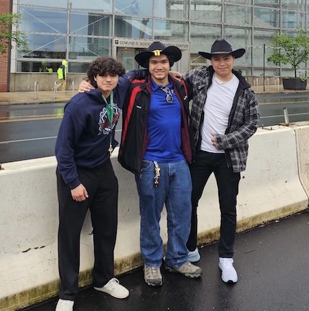 three team member pose outside