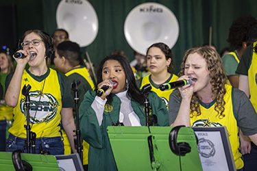 The Green Machine band plays music, entertaining the waiting crowds.