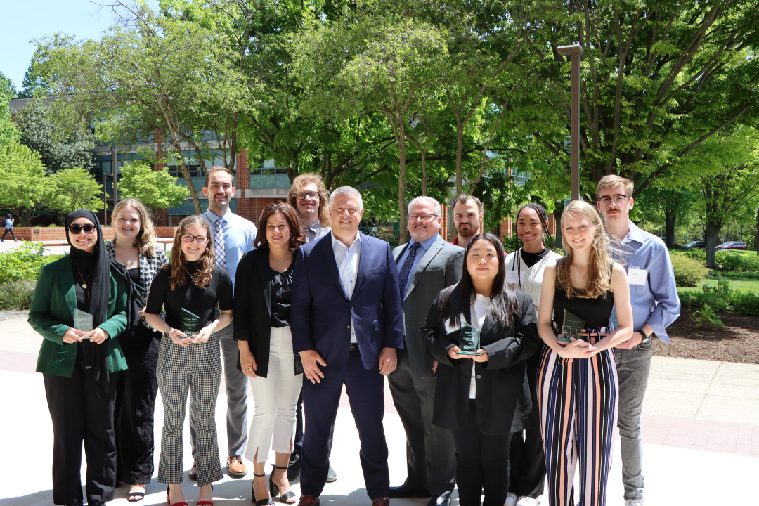 Peraton award winners posing with Peraton representative outside