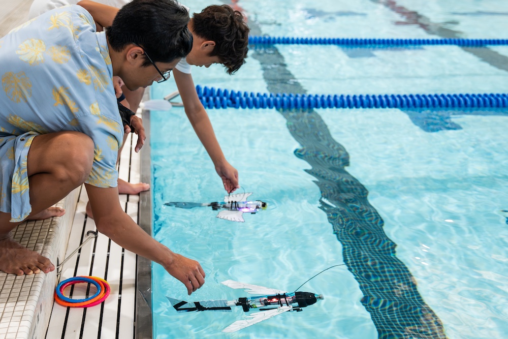 students testing their gliders in the pool