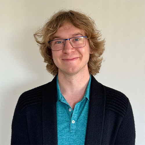 CS professor Greg Stein has long blonde hair and wears a blue, collared shirt