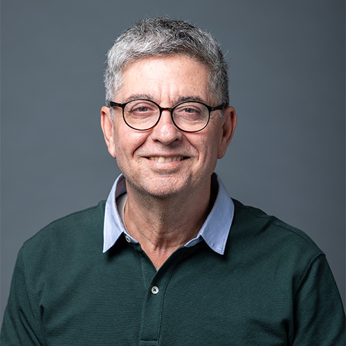 GM faculty Wassim Masri wears a green sweater and cool glasses