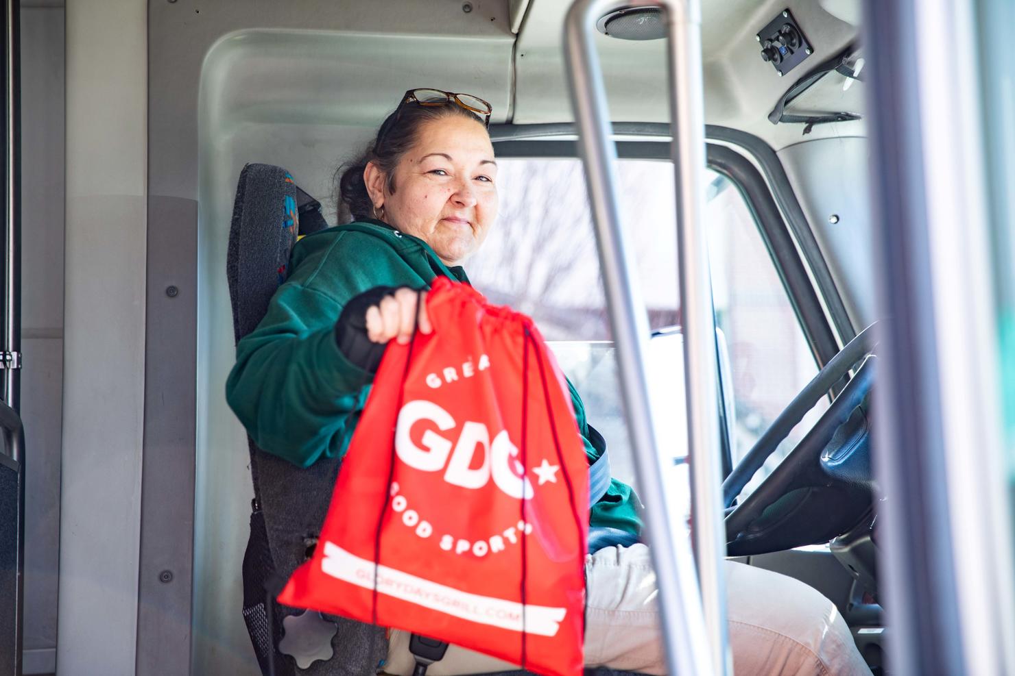 A transit driver holds the appreciation gift bag she received for Transit Driver Appreciation Day