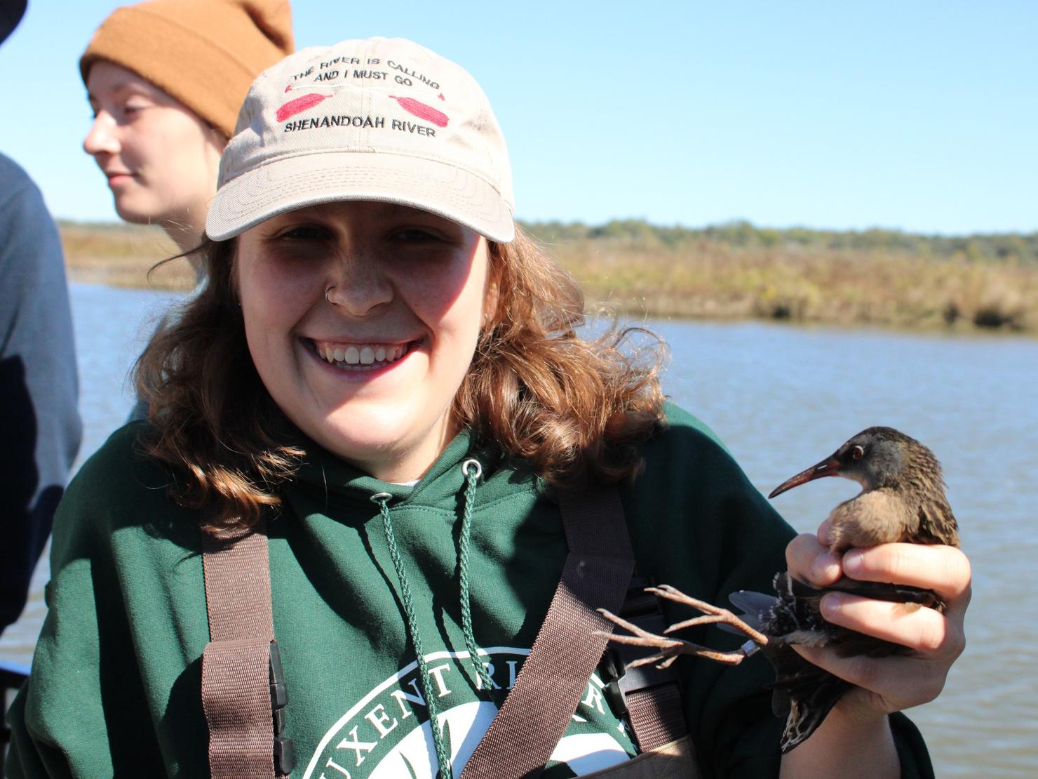 Student holds a marsh bird while learning the important conservation skill of bird banding
