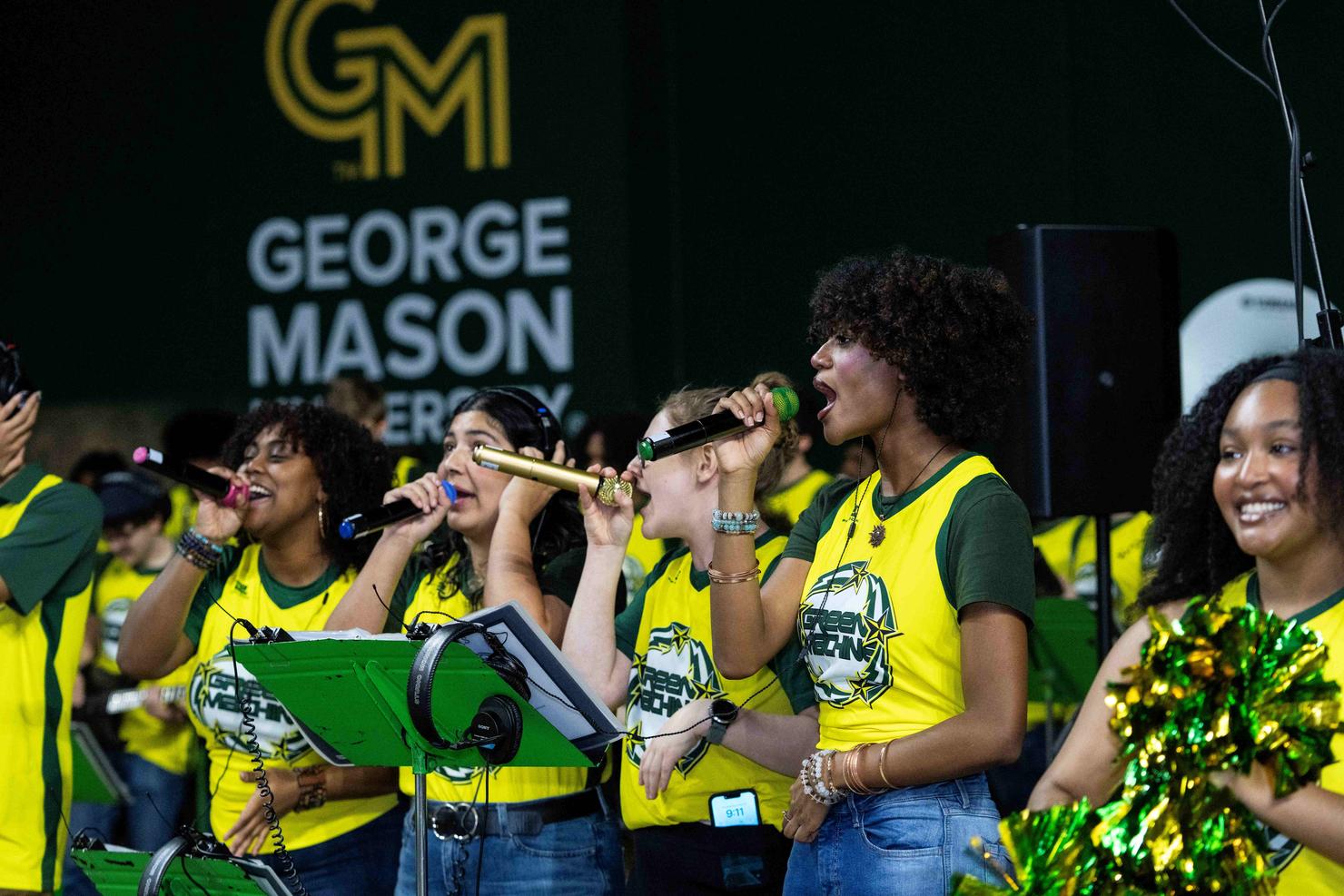 The Green Machine pep band sings and plays their instruments at the Commencement ceremony