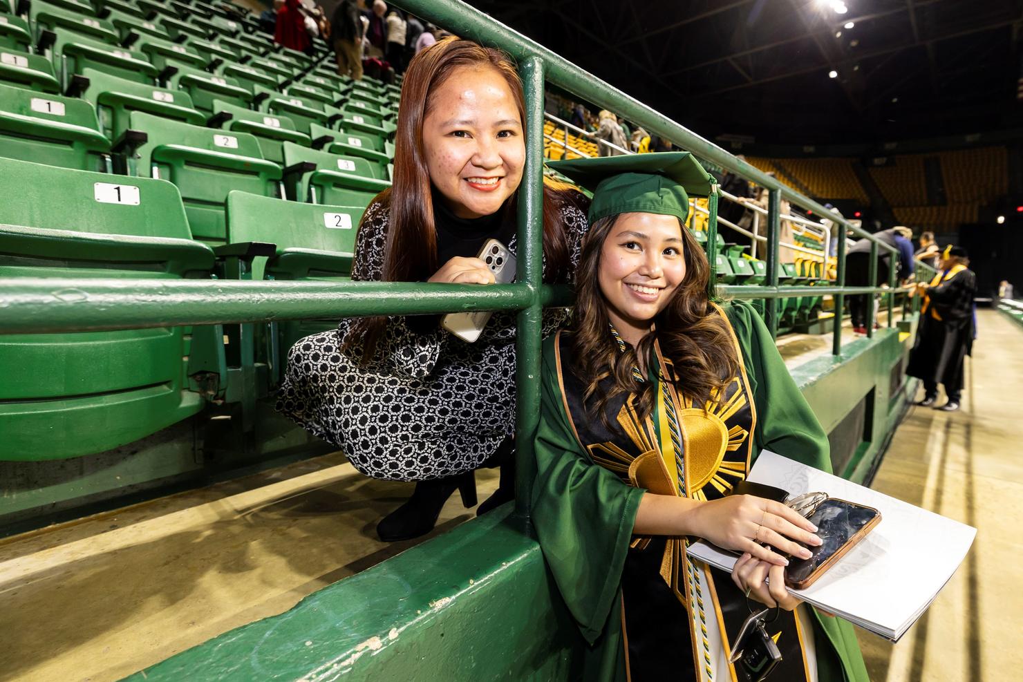A student meets up with her family member in EagleBank Arena after Commencement