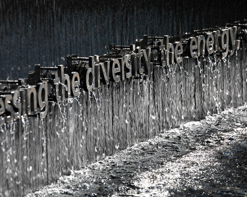 Water pours from the granite face of the Roger Wilkins memorial fountain