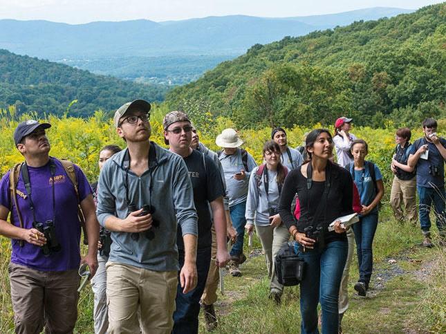 Students trek through a hilly area.