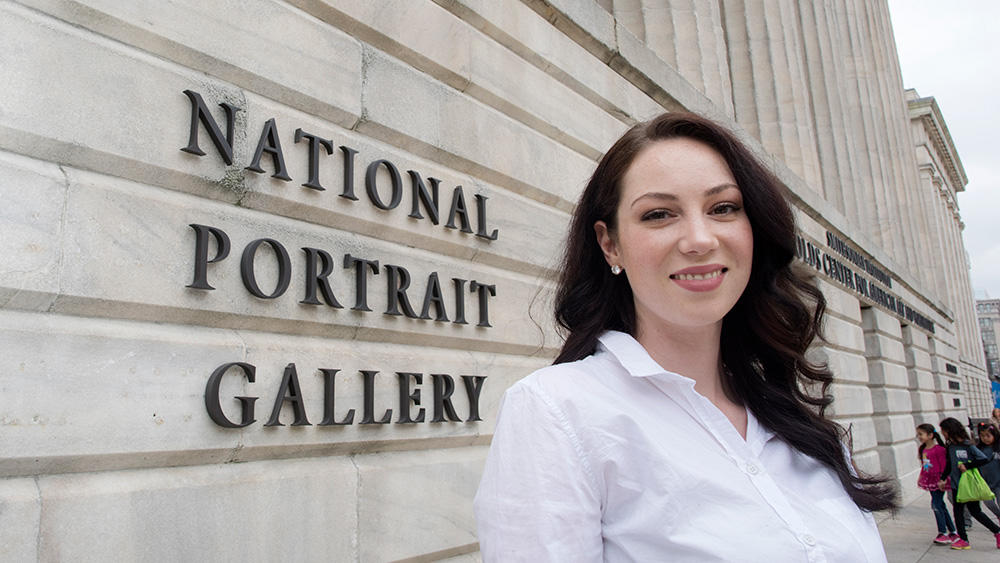 A student stands outside by the sign for the National Portrait Gallery in Washington, DC