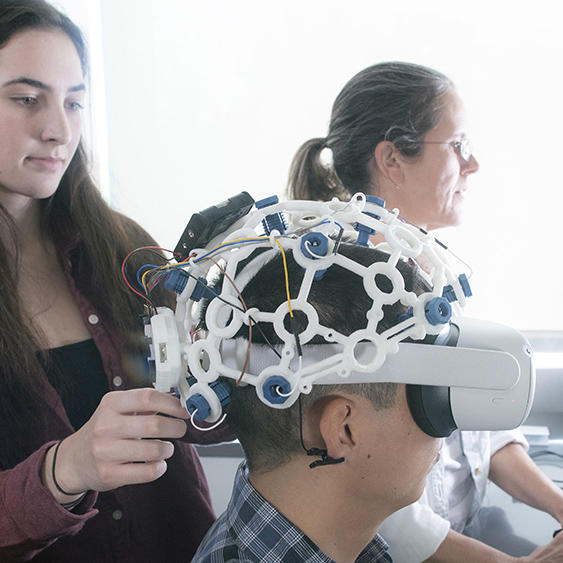 two students work with AI headgear in a VR setting