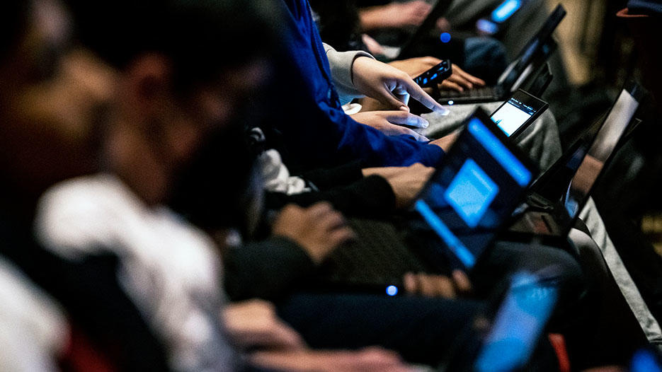 A blurred view of people working on laptops