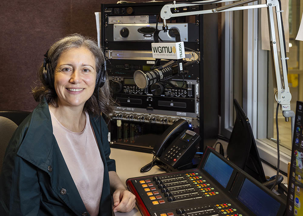 Alessandra Lucini sits at the microphone to record an episode of Access to Excellence