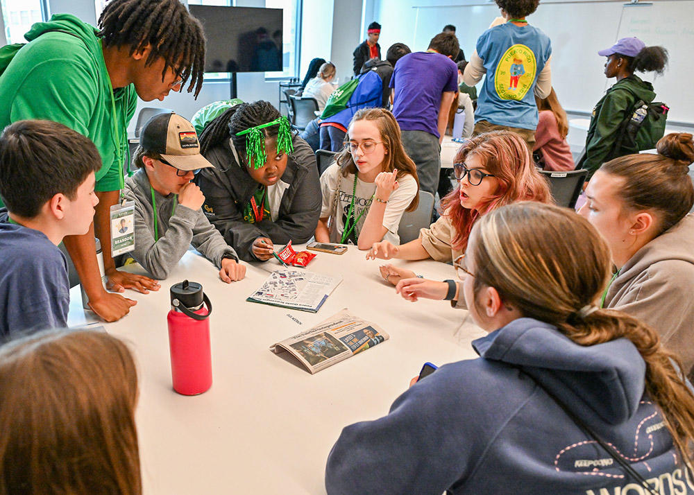 students sitting around a table, working on a problem.