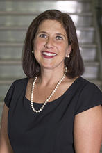 Lisa Gring Pemble is wearing a navy short sleeved dress and pearls