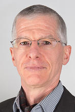 Rainold Löhner wears a checkered collared shirt and blazer