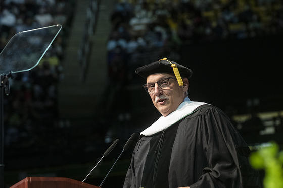 Stu Shea addresses the graduates in his doctoral regalia