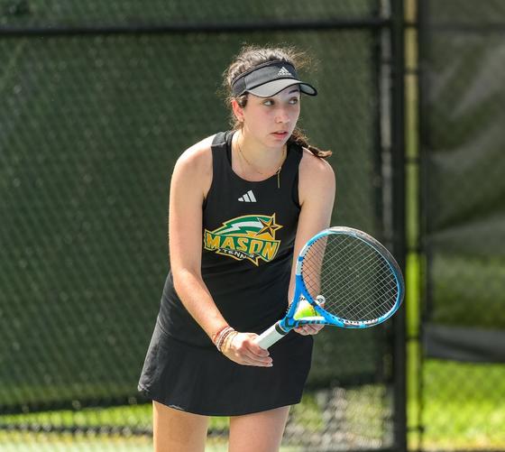 Maïlys Faur plays on a tennis court in a George Mason tennis uniform