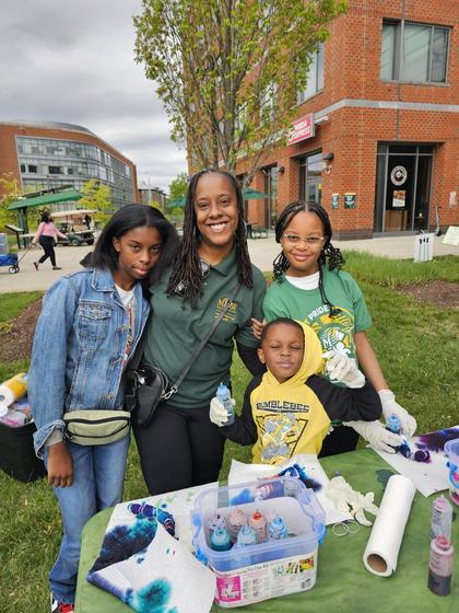 Mason employee and children participate in tie-dye activity on Merten Lawn