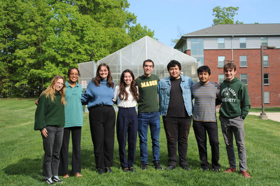 Student research team stands together in front of the President's Park Greenhouse