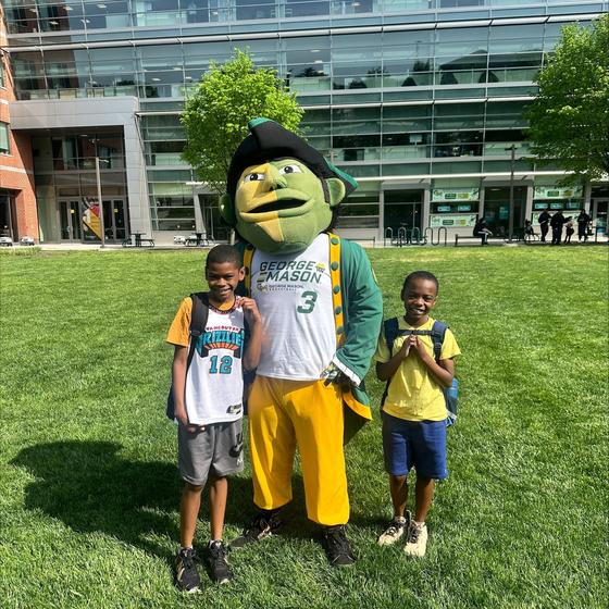 Two children pose with the Patriot mascot on Merten Lawn