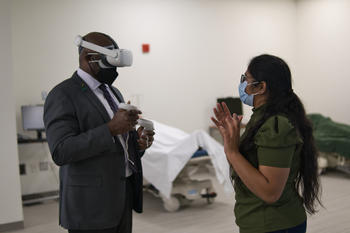 Image of Sindhu Mallala showing President Gregory Washington the VR simulation technology