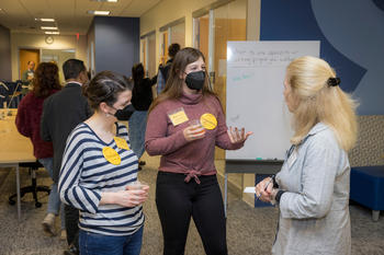 Writing Center consultants Laura Pixley and Shelby Rothberg describe the Lab’s services to a guest at the open house Photo by John Boal
