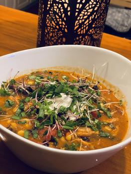 A bowl of Tex Mex Chicken Soup on a wooden table.