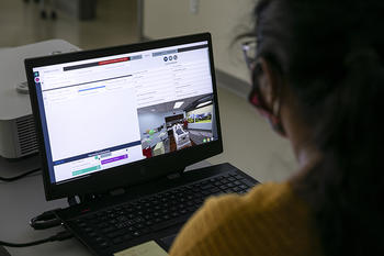 female student sitting in front of a computer running a VR simulation