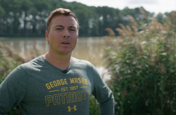 Celso Ferreira standing in wetlands near the Chesapeake Bay
