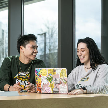 Two students looking at a laptop.